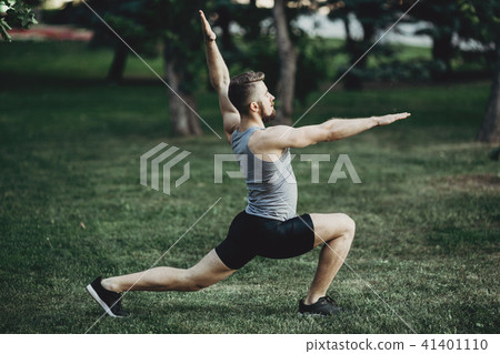 Muscular fit man doing yoga in morning park 41401110