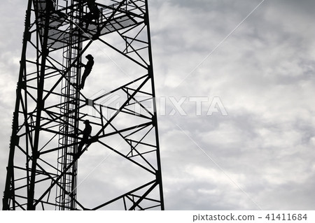 Workers climbing to repair telecommunication tower 41411684