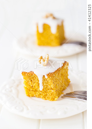 Two pieces walnut carrot cake with icing cream. 41412325