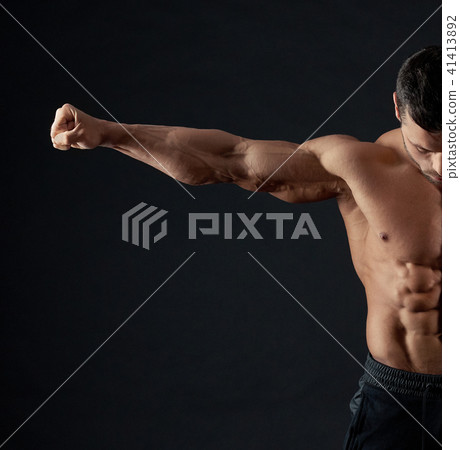 Strong sportsman demonstrating his arm muscles. 41413892