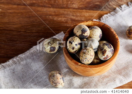 Bowl with eggs quail, eggs on a homespun napkin on wooden table, close-up, selective focus Bowl with eggs quail, eggs on a homespun napkin on wooden table, close-up, selective focus 41414040