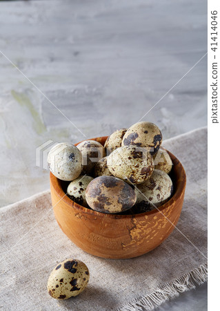 Bowl with eggs quail, eggs on a homespun napkin on grey background, close-up, selective focus Bowl with eggs quail, eggs on a homespun napkin on grey background, close-up, selective focus 41414046