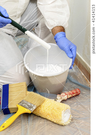 Painter paints the wall with the tint of white. 41414153