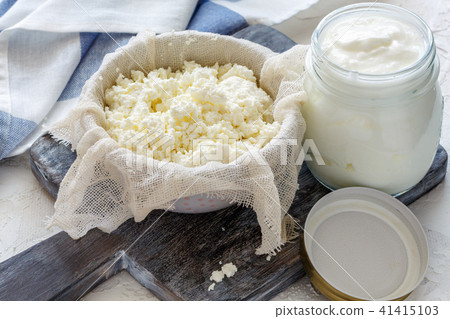 Cottage cheese in a bowl and jar of sour milk. 41415103