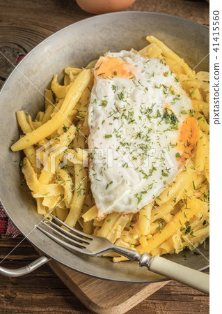 Fried egg served with yellow beans. 41415560