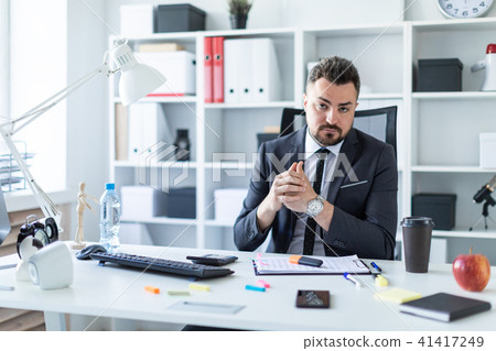 A man is sitting in a chair in the office at the table. A man is sitting in a chair in the office at the table. 41417249