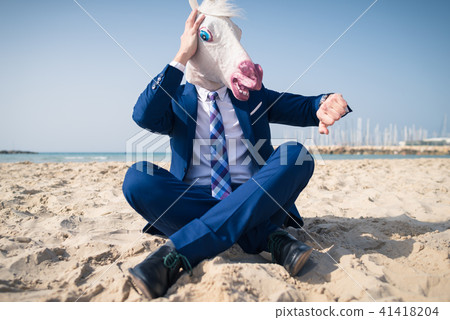 Stylish manager in comical mask and elegant suit 41418204