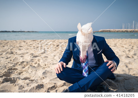 Stylish traveler on vacation in a suit sits on the beach 41418205