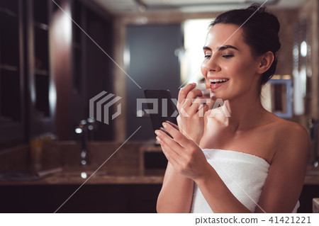 Delighted female beautifying herself before date Delighted female beautifying herself before date 41421221
