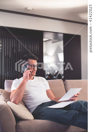 Happy man discussing business issues by cellphone in apartment  41422025