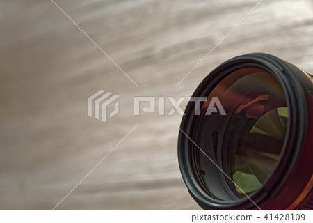 Camera lens with reflections on wooden background 41428109