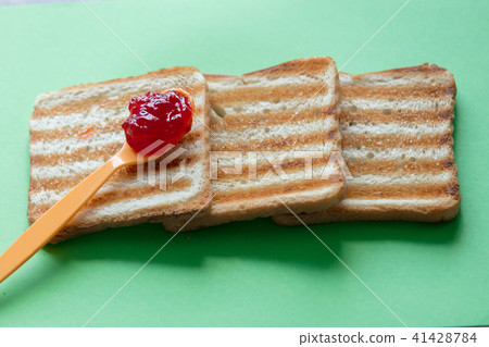 Slices of toast bread and tea spoon with jam 41428784
