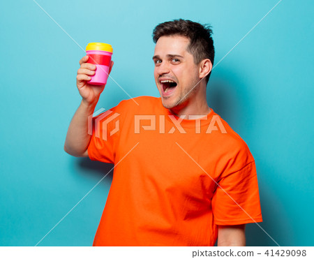 man in orange t-shirt with cup of coffee 41429098