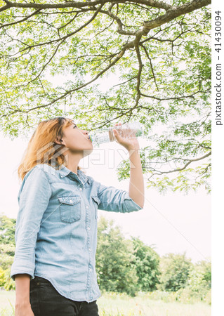 young beautiful  woman drinking water at summer  41430094