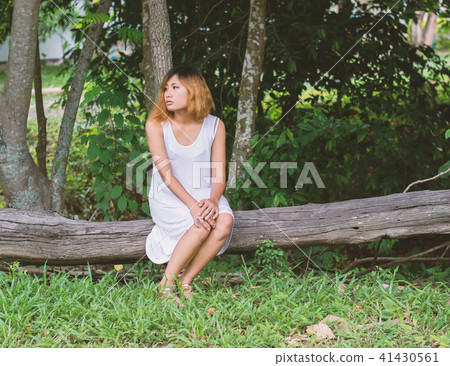 Young beautiful woman sitting at wood bench and  41430561