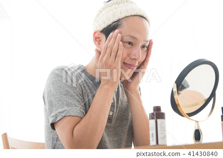 男士美容年轻男子穿上化妆水 图库照片