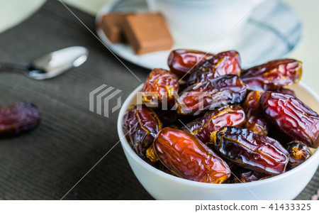 Sweet dried organic dates fruit in small bowl Sweet dried organic dates fruit in small bowl 41433325
