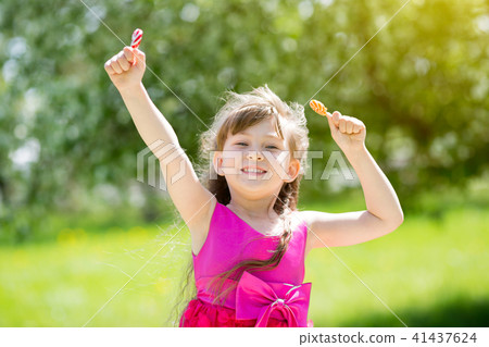A girl in a red dress with sweets in her hands. 41437624