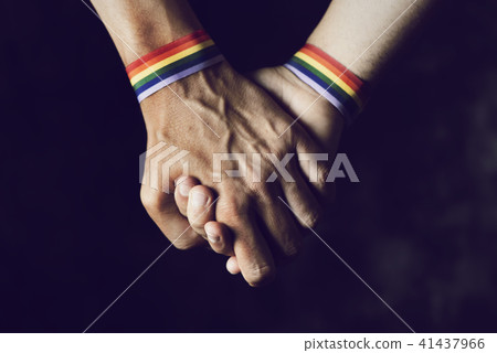 men holding hands with rainbow-patterned wristband men holding hands with rainbow-patterned wristband 41437966