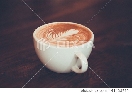 Coffee cup with latte art on wooden background . Coffee cup with latte art on wooden background . 41438711