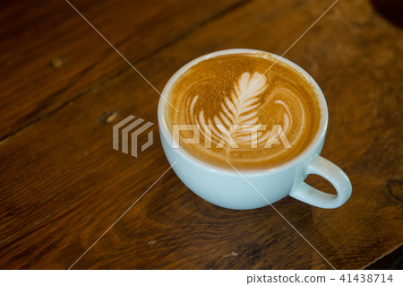 Coffee cup with latte art on wooden background . Coffee cup with latte art on wooden background . 41438714