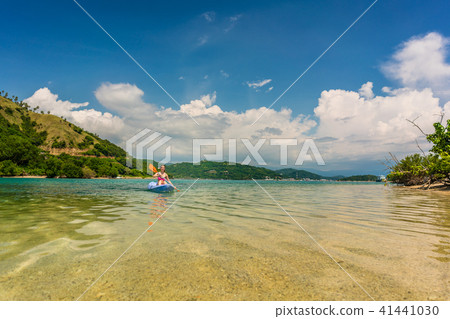 Young woman paddling during vacation in an idyllic travel destination 41441030