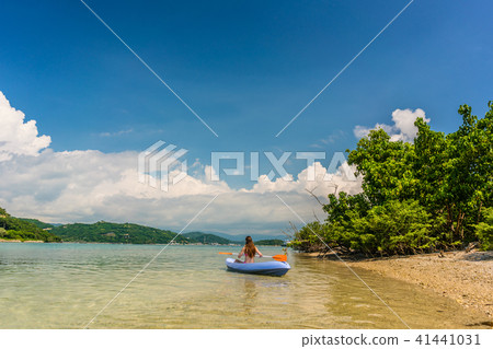 Young woman paddling during vacation in an idyllic travel destination 41441031
