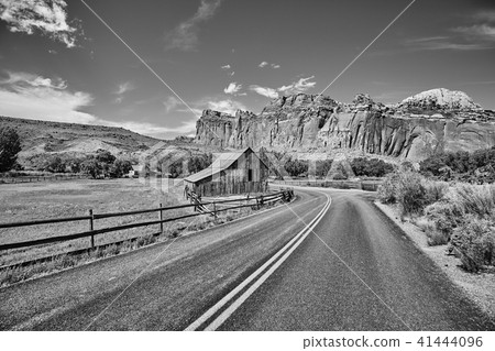 Black and white picture of a barn by a road. Black and white picture of a barn by a road. 41444096