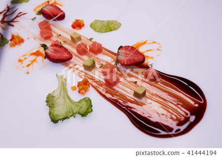 Conceptual Salad of Salmon and Avocado Cubes. Decorated with sauce, strawberries and green leaves Conceptual Salad of Salmon and Avocado Cubes. Decorated with sauce, strawberries and green leaves 41444194