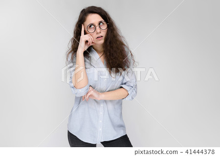 Young brunette girl with glasses. The girl pulls her lips for a kiss. The girl put her hand to her 41444378