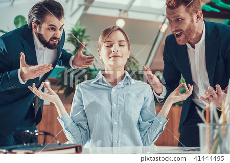 People shout at meditating worker in office. 41444495
