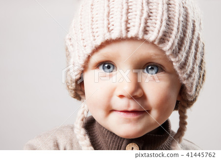 Portrait of a cute baby girl in a huge brown knitted hat. Isolated on white background. Portrait of a cute baby girl in a huge brown knitted hat. Isolated on white background. 41445762