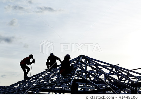 Contractor in Silhouette working on a Roof Top 41449106