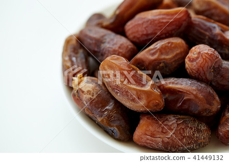 Bowl of dried dates isolated on white backgroun Bowl of dried dates isolated on white backgroun 41449132