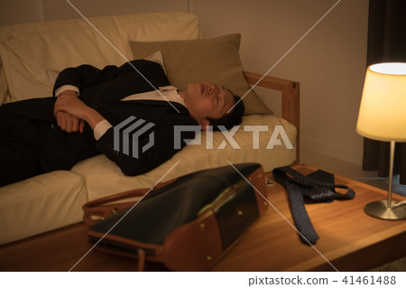 一個年輕的商人上床睡覺，在沙發上睡覺 41461488