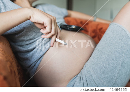 Pregnant woman smokes a cigarette Pregnant woman smokes a cigarette 41464365