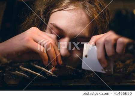 Close-up of the hands of an addicted young man snorting powdered substance Close-up of the hands of an addicted young man snorting powdered substance 41466630