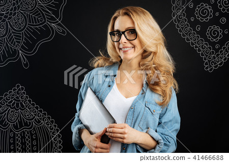 Cheerful freelance worker holding a tablet and smiling Cheerful freelance worker holding a tablet and smiling 41466688
