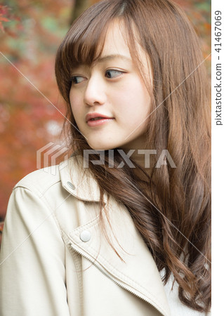 A woman in autumn leaves 41467069