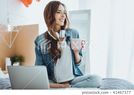 Nice delighted woman holding a cup of tea Nice delighted woman holding a cup of tea 41467377
