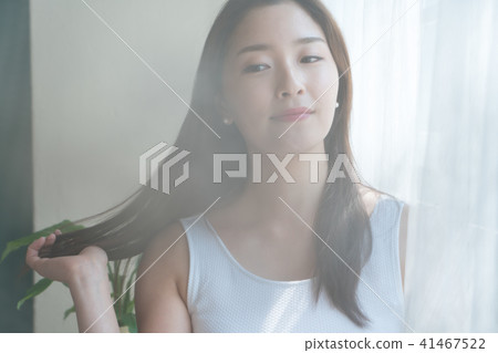 A woman standing at a window A woman standing at a window 41467522