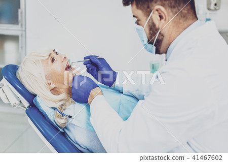 Pleased retired female visiting her dentist 41467602