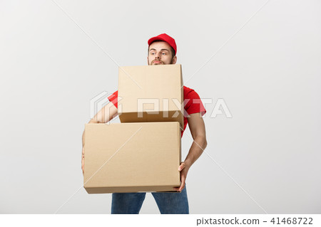 Delivery Concept: Man hardly carries the cardboard boxes, isolated on white background. Concept of Delivery Concept: Man hardly carries the cardboard boxes, isolated on white background. Concept of 41468722