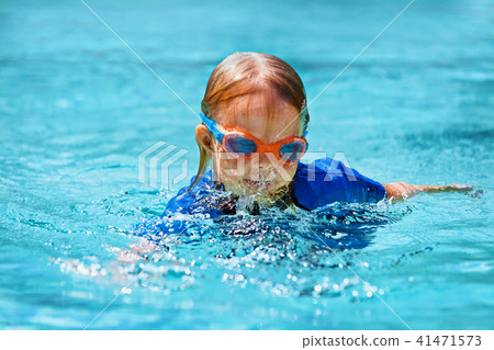 Little child swimming lesson in outdoor pool 41471573