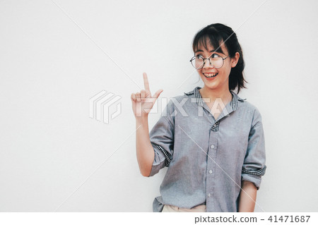 Teenage girl smiling and pointing fingers away Teenage girl smiling and pointing fingers away 41471687