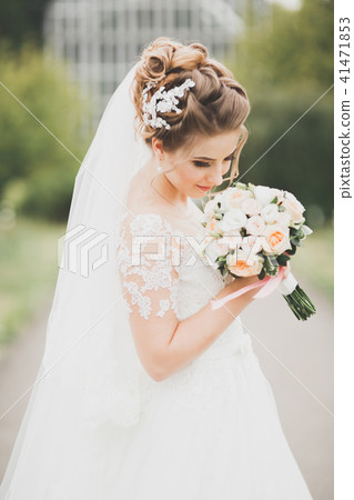 Beautiful bride posing in wedding dress outdoors Beautiful bride posing in wedding dress outdoors 41471853