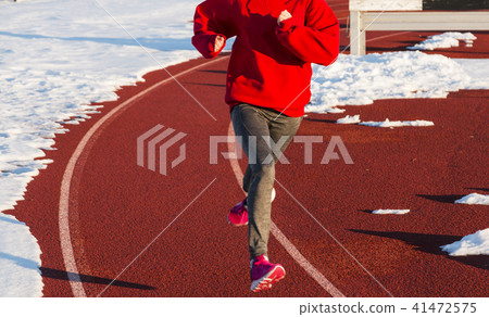 Running on a track surrounded by snow 41472575