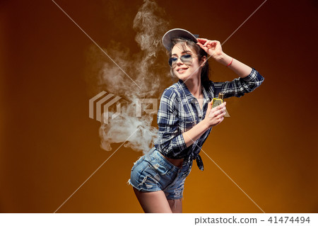 Woman standing and vaping in studio 41474494