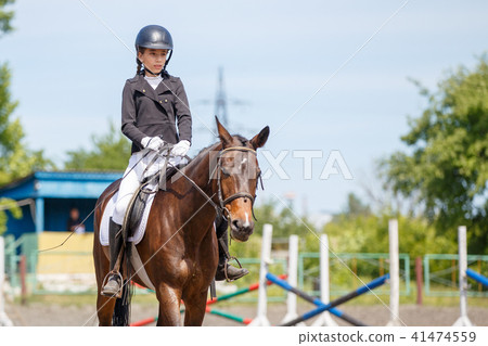 Young girl riding horse on equestrian competition 41474559