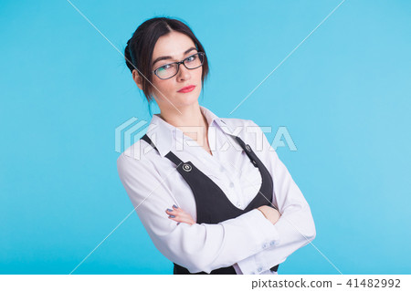 A pretty teenage brunette girl with glasses on blue background 41482992